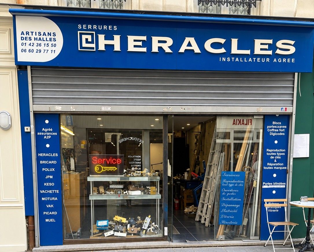 La devanture bleue d'Artisans des Halles, 12 rue Mandar : enseigne Serrures Héraclès installateur agréé, cartouche avec les deux numéros, vitrine de serrures et néon Service